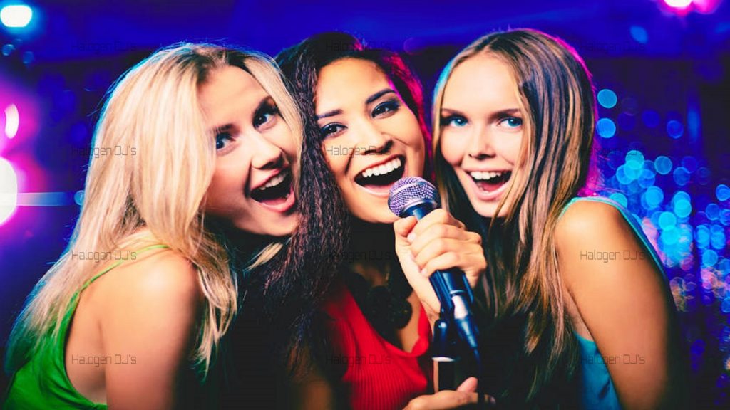 A well dressed trio sing their best into the microphone.